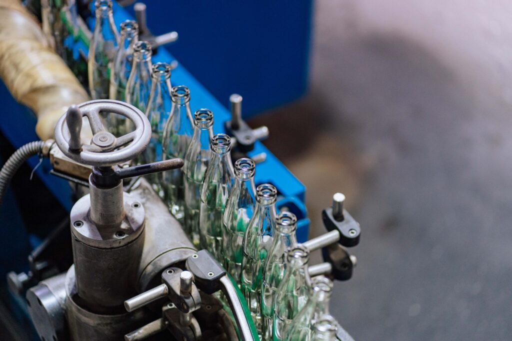 Automated glass bottle manufacturing machinery on a factory production line