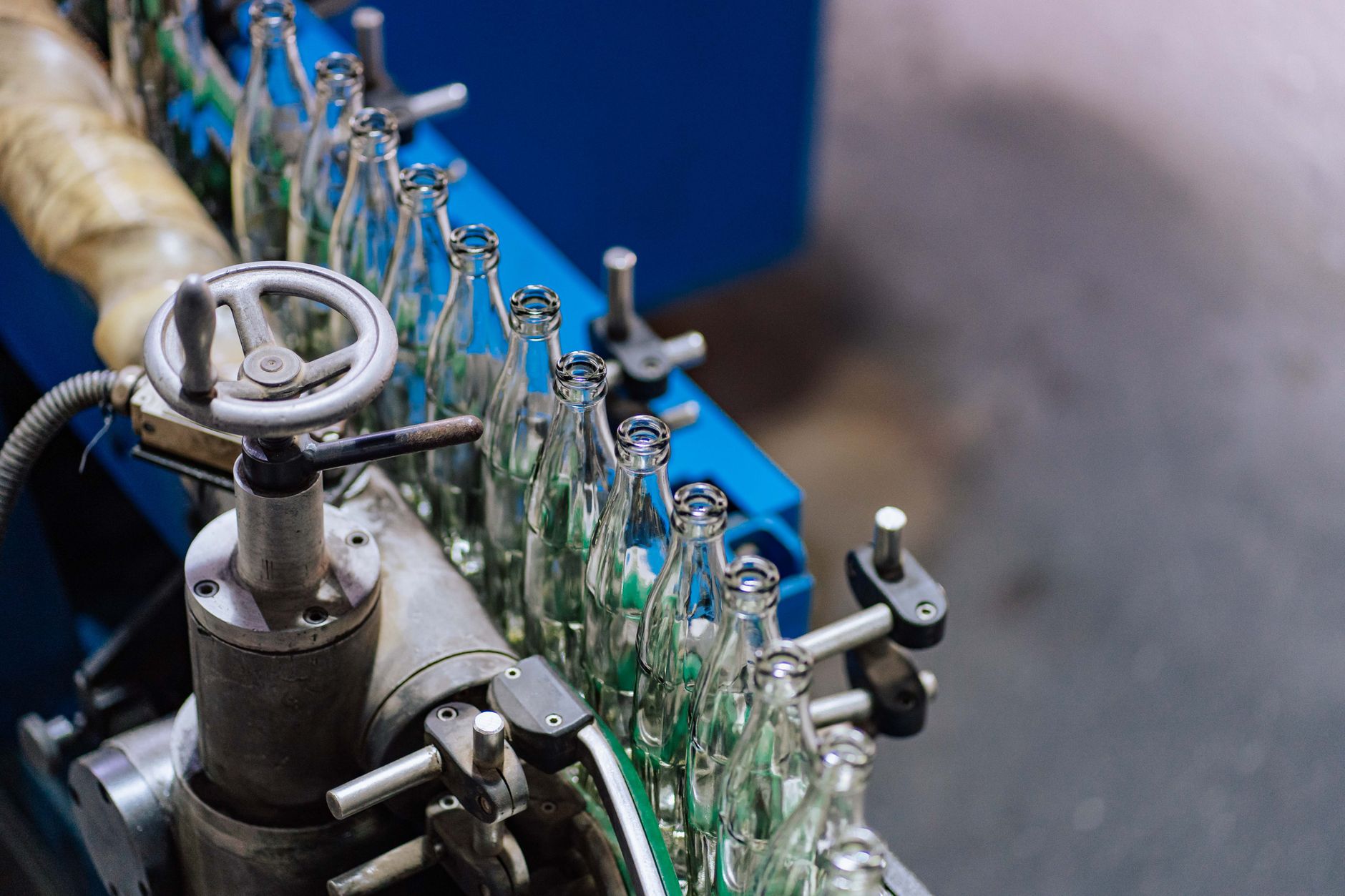Automated glass bottle manufacturing machinery on a factory production line