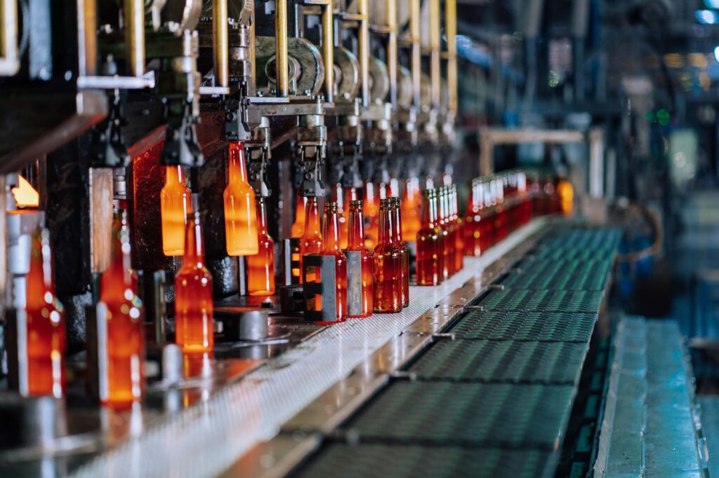 Glass bottles moving through an automated production line at a glass bottle factory